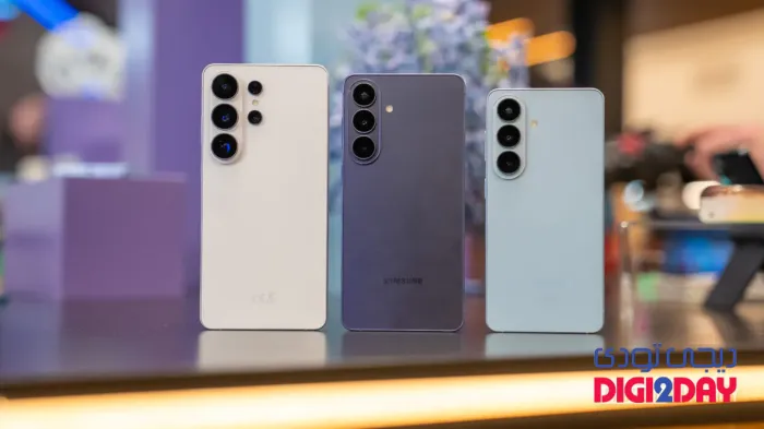 Three Samsung Galaxy smartphones stand upright on a display table, showing their rear camera arrays (white, purple, and light blue).